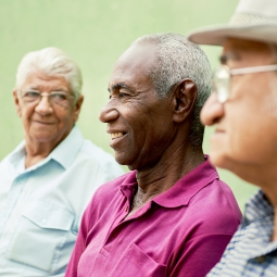 Three older men sit in discussion